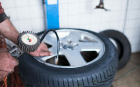 mechanic checking tire air pressure