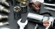 automobile tune up tools and parts, including socket wrench, spark plugs, distributor coil, sockets, and a wrench